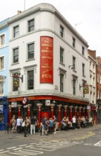 People sitting outside The Coach and Horses pub, Romilly Street, Soho, London, England, UK