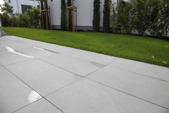 Modern terrace with large, light-coloured terrace tiles on a new detached house