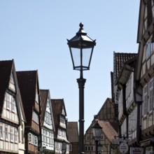 Street with half-timbered houses and historic street lamp in the old town centre, Celle, Lower
