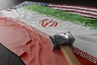 Large hammer resting on american and Iranian flags