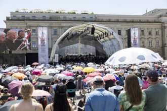 Audience with sun protection at the Staatsoper für alle, a free open-air concert with conductor