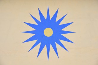 Blue stylised star with yellow centre on beige background, Rüdesheim am Rhein, Rhine Valley,