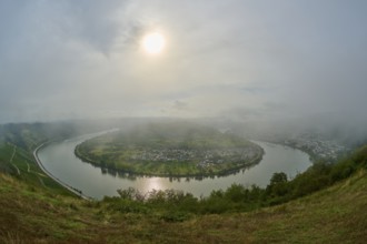 River landscape with hills in the sunlight, shrouded in mist and clouds, summer, Rhine bend