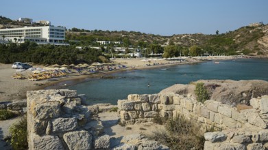 Coastal view with beach and neighbouring ruins, in the background a hotel, Agios Stefanos Beach,