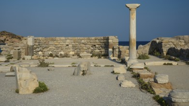 Ancient site with a single stone column and ruins, near the sea, Agios Stefanos Beach, Agios