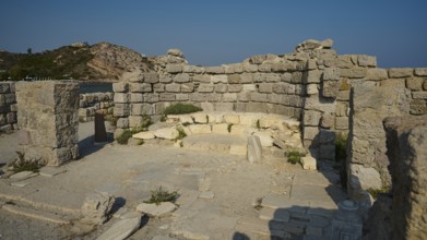 Historic site with preserved stone walls, under a clear sky, Agios Stefanos Beach, Agios Stefanos