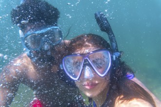 Young couple exploring the underwater world, enjoying their snorkeling adventure in crystal clear