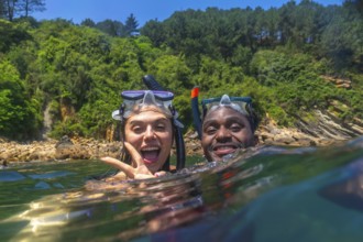 Interracial couple snorkeling together in the vibrant ocean, enjoying a fun filled summer vacation