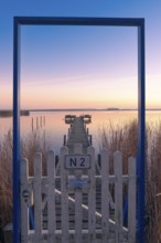 View along a footbridge through a door frame to the Steinhuder Meer in the evening light, Great