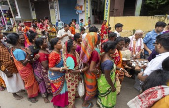 Devotees throng to have food as they arrives to visit Kamakhya Temple during Ambubachi Mela, in