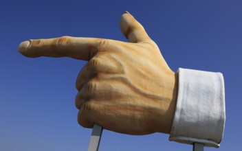 Plastic sculpture of a human hand with an outstretched index finger to indicate a direction
