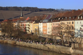 People enjoying the first spring sunshine along the old town houses on the Main, Würzburg, Lower