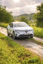 Car on a rural road surrounded by trees and a wide landscape, Deer E- CarSharing, Renault Megane