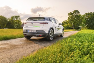 Renault on a country road, surrounded by lush green meadows and trees, Deer E- CarSharing, Renault