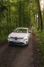 Renault drives on a shady forest path between tall trees, Deer E- CarSharing, Renault Megane