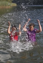 Girls splashing in the lake, Allgäu, Bavaria, Germany, Allgäu, Bavaria, Germany