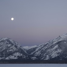 Moonset... Rocky Mountains (Wyoming, USA), full moon in ice-cold night over the Grand Teton Range