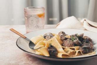 Delicious pappardelle pasta with mushrooms and cream served on a white plate
