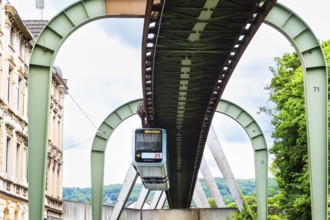 The Wuppertal suspension railway runs through Vohwinkel in front of buildings from the Wilhelminian