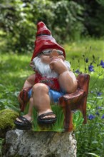 Sitting garden gnome in a garden, Bavaria, Germany