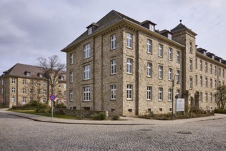 Tax office, sandstone building, bare wintry trees, diffuse light, slightly sunny, cloudy, street