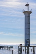 Man and woman sitting on a concrete platform at the base of the graffiti, covered Broadwater Beach