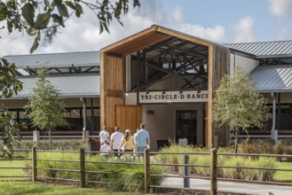 Family entering the Tri-Circle-D Ranch horse stables in the Fort Wilderness Campground and Resort