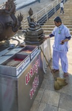 Worker cleaning Buddhist statue in fron of the Guan Yin (Goddess of Mercy) statue at Wat Huay Pla