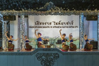 Traditional Thai dancers perform on a lighted stage at the night market in downtown Chiang Rai,