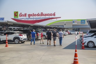 American men walking in parking lot towards the Big C Supercenter in Chiang Rai, Thailand
