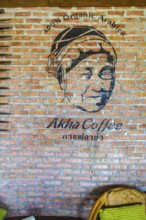 Logo painted on brick wall at the Akha Cottage restaurant and coffee shop in Chiang Rai, Thailand