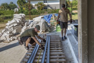 American men preparing metal studs while volunteering to help build the Grace Language School and
