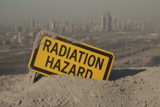 Radiation warning sign with text Radiation Hazard in scorched earth. with destroyed city. Symbol