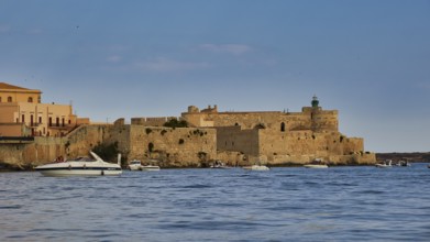 Castello Maniace, Maniace sea fortress, old defence defence tower by the sea with passing boats