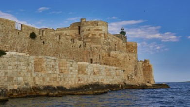 Castello Maniace, Maniace sea fortress, old castle by the sea under a blue sky, surrounded by stone