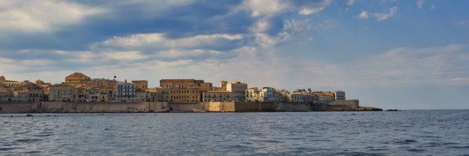 Historic city scenery on the coast under a slightly cloudy sky, boat trip around the island of