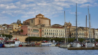 Harbour view with yachts and old buildings under a slightly cloudy sky, boat trip around the island