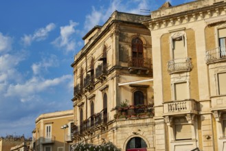 Close-up view of historic buildings with balconies and windows under blue sky, Ortigia Island,