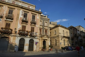 Street scene with old buildings and balconies under a blue sky, Ortigia Island, Isola di Ortigia,