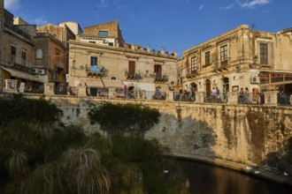 Largo Aretusa, Fonte Aretusa, View of a busy bridge and old buildings under a blue sky, Ortigia
