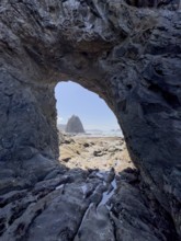 Large rock with a hole and people in the foreground, Hole in The Wall, Rialto Beach, Olympic