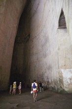 Cave Ear of Dionysus, group of people in a high rock cave, exploring the natural structure,