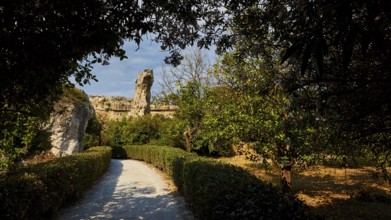 Park, A path leads through a sunlit landscape of ruins surrounded by trees and bushes, Neapolis