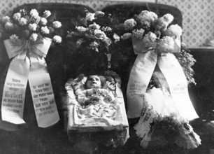 Dead baby in a coffin, Infant mortality, 1920s, An infant lies in a coffin surrounded by floral