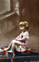 Child sitting on chamber pot, 1920s, A small child sits on a potty, smiles and wears old-fashioned