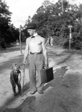 Man with bare upper body travelling with suitcase and son, 1920s, A man with hat and suitcase