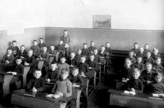 School class, all boys, 1920s, Young schoolboys sitting in a classroom with textbooks and writing,