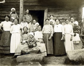 Large family in the countryside, 1920s, Group of woman and children in front of a wooden house,