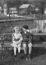 Two girls sitting on a park bench, 1930s, Two laughing children sitting next to each other on a