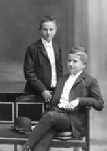 Two boys in suits, 1930s, Two boys in elegant suits pose confidently, one standing the other